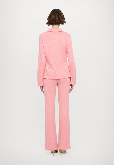 Pink floral embossed matching set, featuring a fitted blazer with long sleeves and flared pants, made from textured fabric.