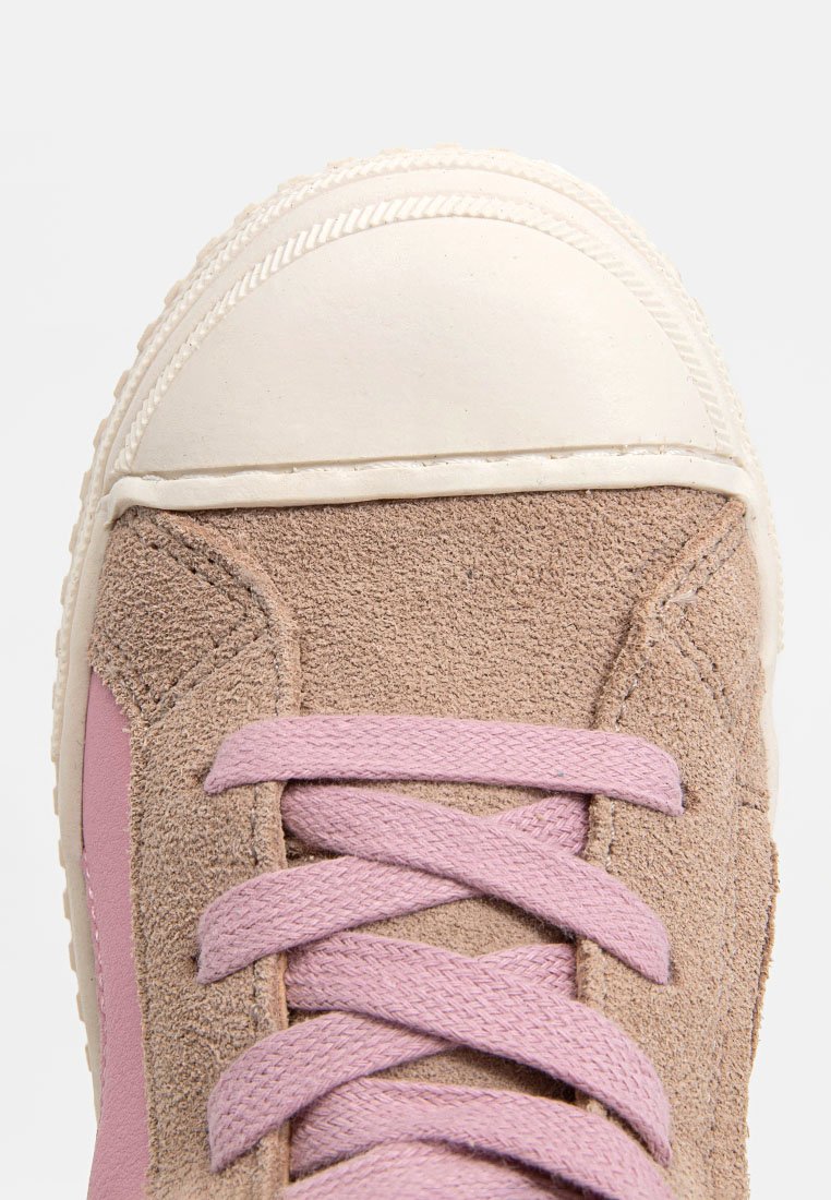 Braune Wildleder-Sneaker mit Gummikappe, pinken Akzenten und passenden Schnürsenkeln. Abgerundete Form mit strukturiertem Obermaterial und gestickten Details.