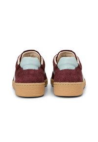 Bordowe zamszowe sneakersy z jasnoniebieskimi skórzanymi akcentami, teksturowanym tyłem, beżową podeszwą i kontrastowym przeszyciem. O okrągłym kształcie i niskim profilu.