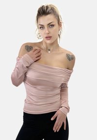 Ljusrosa off-shoulder topp med rynkad tygdetalj, långa ärmar och mjuk textur. Matchas med svarta tajta byxor.