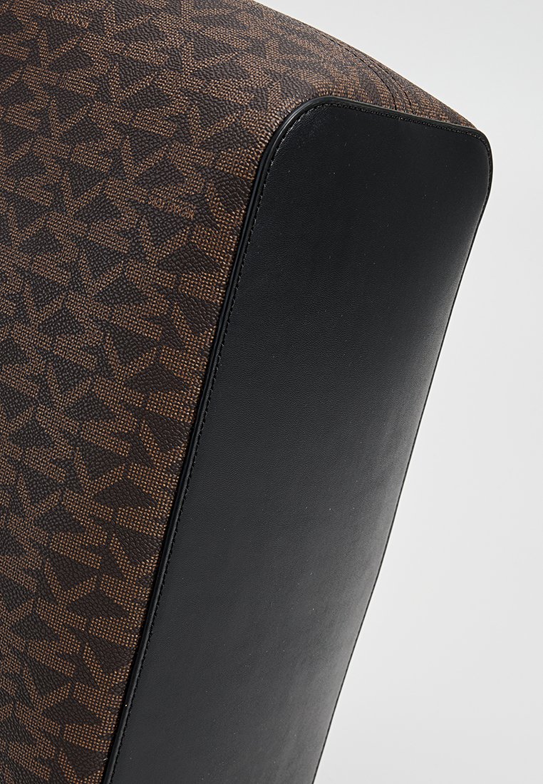 Rivestimento in tessuto marrone con un motivo geometrico su un lato, in contrasto con la pelle nera liscia sul lato adiacente.