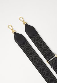 Cinghia da spalla in tessuto nero con dettagli in metallo dorato, caratterizzata da un motivo in rilievo con logo e estremità in pelle. Design resistente, adatto per borse.