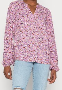 Blouse à manches longues florale en lavande avec un décolleté en V, dotée d'une patte de boutonnage et de poignets élastiques. Petits motifs floraux multicolores partout.