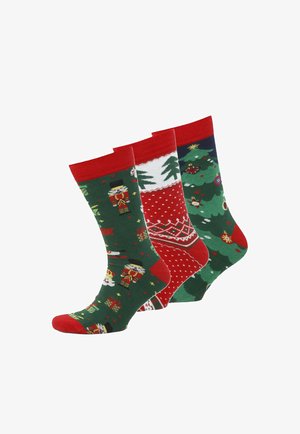 Drei Paare bunter Socken: grüne mit Nussknacker-Motiv, rote mit weißen Punkten, dunkelblaue mit Weihnachtsbäumen und -ornamenten.