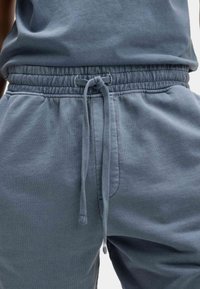Blaue Baumwoll-Sweatpants mit elastischem Bund und verstellbarem Kordelzug. Verfügt über Seitentaschen und einen weichen, strukturierten Stoff.
