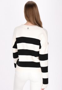 Sweter w kolorze czarnym i kremowym z poziomymi paskami, okrągłym dekoltem, ściągaczem u dołu oraz detalem z logo na górnej części pleców. Miękka dzianina.