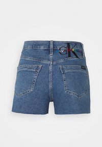 Denim shorts in medium blue, featuring a high waist, two back pockets, and embroidered branding in multicolor on the waistband.