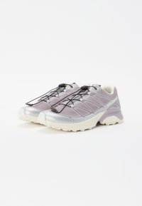 Sportliche Schuhe in Helllila mit silbernen Akzenten, ausgestattet mit einem Obermaterial aus Mesh, elastischen Schnürsenkeln und einer strukturierten Sohle für besseren Halt.