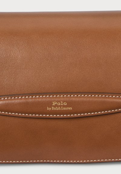 Brūna ādas somiņa ar gludu tekstūru, baltiem šuvju akcentiem un iepresēto "Polo by Ralph Lauren" zīmolu zeltā priekšpusē.