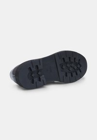 Semelle de chaussure en caoutchouc noir avec des crans profonds, dotée d'un bord lisse et d'un marquage de taille visible "42". Surface texturée pour une meilleure adhérence.