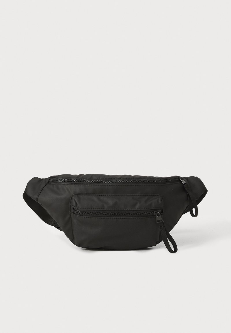 Sac banane noir en nylon de forme arrondie, équipé de deux poches zippées et d'une sangle ajustable. Texture lisse avec un design minimaliste.