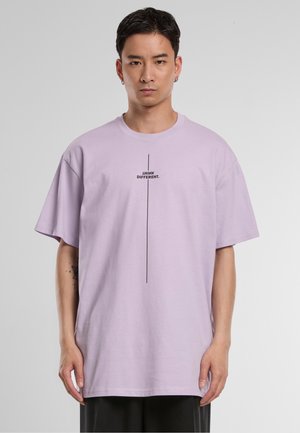Short-sleeve lavender t-shirt in cotton, featuring black text "THINK DIFFERENT." centered vertically. Relaxed fit with dropped shoulders.
