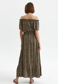 Off-shoulder, lång maxi-klänning i mönstrad brun tyg med elastisk midja och volangnederdel, med korta ärmar och lös passform.