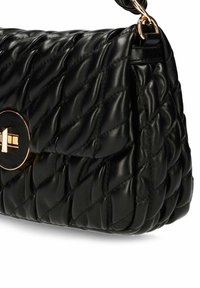 Zwarte gewatteerde leren handtas met goudkleurige draaislotsluiting en bijpassende kettingriem hardware.