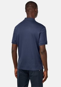 Námořnická modrá polokošile s krátkým rukávem a plochým límcem. Hladká látka ze směsi bavlny, s rovnými okraji a postranními rozparky.