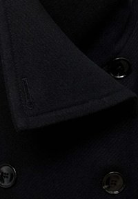 Black wool coat collar with a soft texture, featuring black buttons and a stitched detail on the collar.