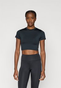 Sort kort atletisk t-shirt med rund halsudskæring og korte ærmer, kombineret med sorte leggings i taljen, begge lavet af elastisk stof.