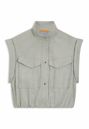 Lys grå ærmeløs skjorte lavet af struktureret stof, med standkrave, to frontlommer og en rynket bundkant.