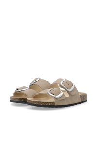 Beige suède sandalen met twee verstelbare zilveren gespen, een gevormde kurken voetbed en een gestructureerde zwarte zool.