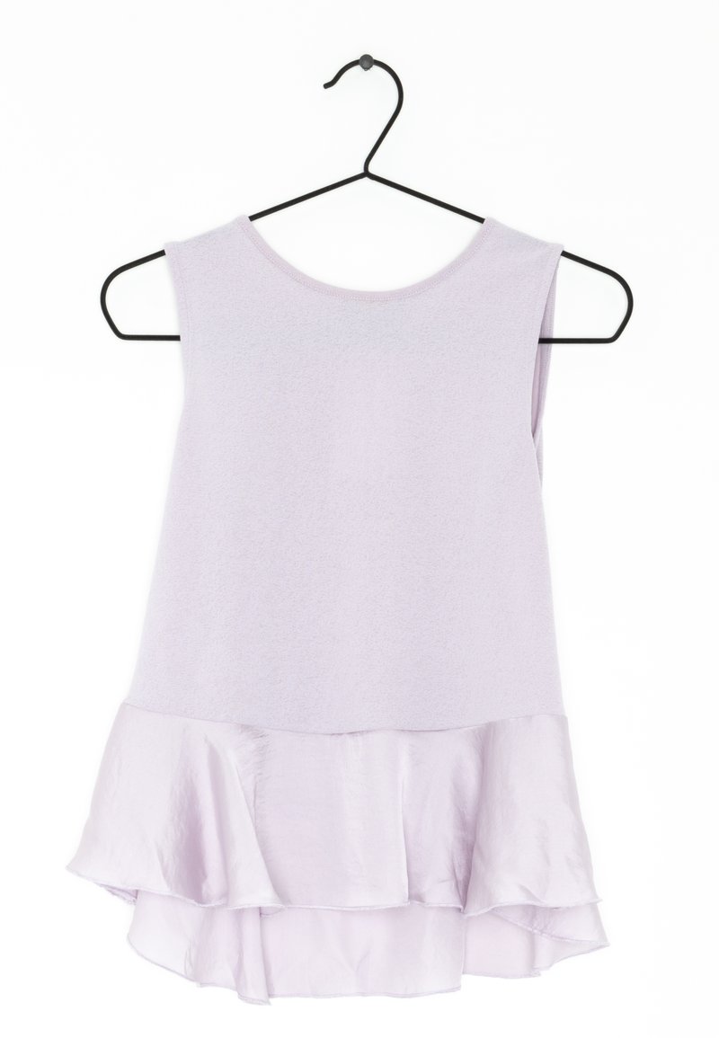 Fialový top bez rukávů s rozšířeným volánkem. Vyrobeno z jemné látky, má kulatý výstřih a volný střih. Visí na černém háčku.