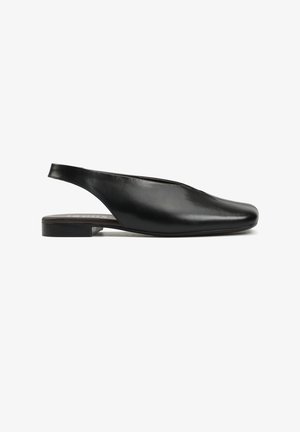 Czarny skórzany płaski but typu slingback z zamkniętym, spiczastym noskiem i niskim, kwadratowym obcasem, widok z boku na białym tle.