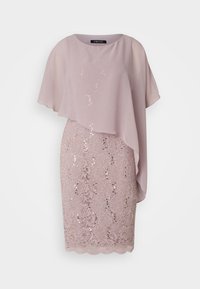 Robe de cocktail mauve clair avec superposition asymétrique transparente et jupe en dentelle sequins, longueur genou, col rond, manches courtes et fluides.