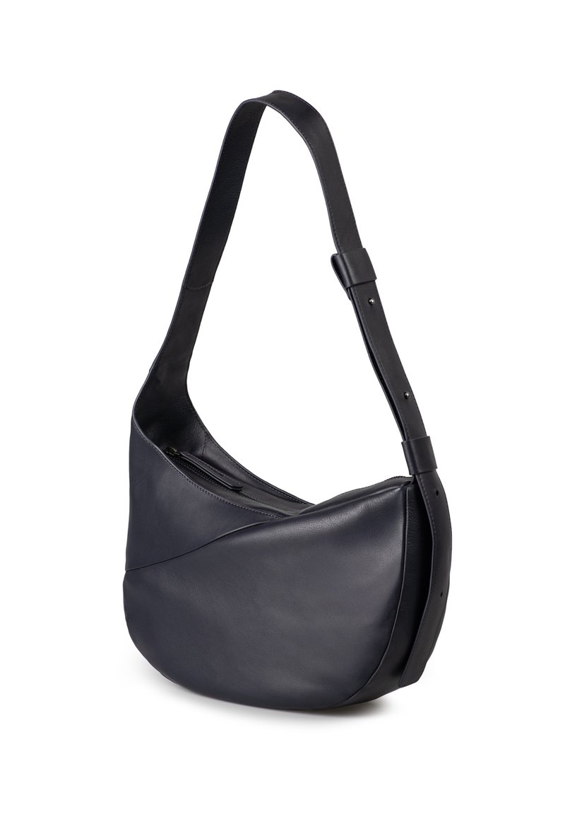 Borsa a spalla in pelle nera con una forma curva e asimmetrica, una tasca con zip e una tracolla regolabile. Texture liscia con hardware minimale.