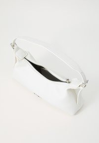 Sac à bandoulière en cuir blanc avec fermeture éclair argentée partiellement ouverte, sangle réglable et forme rectangulaire douce sur fond blanc.