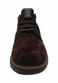 Zapato de ante marrón con puntera redonda, superficie texturada, cordones oscuros y un detalle de costura blanca en contraste a lo largo de la suela.