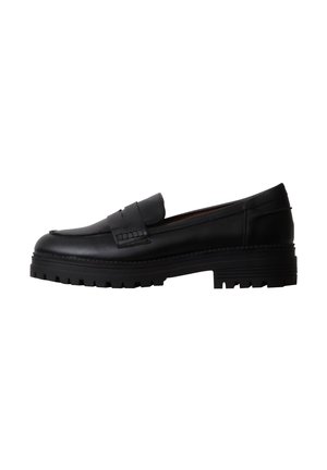 Mocassin noir en cuir avec semelle à crampons épaisse et détail de bride à penny, vu de profil sur fond blanc.