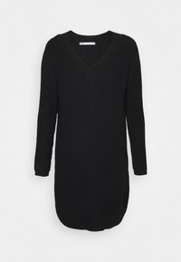 Svart stickad klänning med lång ärm, V-ringning och en något rundad fåll. Det texturerade tyget ger ett mysigt utseende.