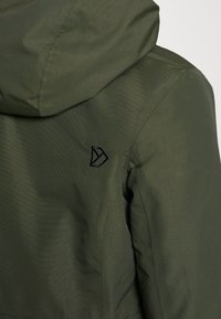 Giacca verde scuro con cappuccio, tessuto liscio e logo nero ricamato sulla spalla. Design strutturato con spalle senza cuciture.