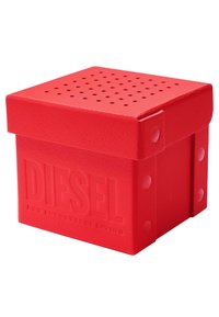 Caja de almacenamiento roja hecha de plástico texturizado con tapa y agujeros de ventilación. Presenta el logo en relieve "DIESEL" en un lado. Forma cuadrada.
