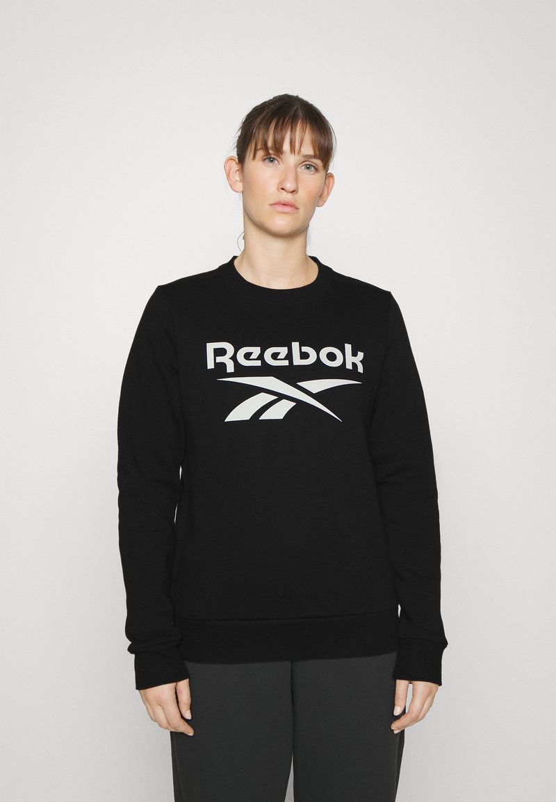 Felpa nera con scollo a girocollo, maniche lunghe e un grande logo grigio Reebok sul davanti. Presenta un orlo e polsini a coste.