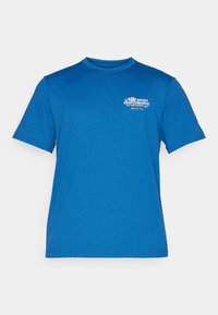 Camiseta deportiva azul hecha de tela suave; cuenta con un cuello redondo y mangas cortas. Incluye texto de marca en blanco en el lado izquierdo del pecho.