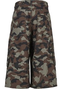 Vedere din spate a pantalonilor scurți cargo pe genunchi cu model de camuflaj maro, verde și negru și buzunare cu clapetă.