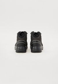 Czarne buty trekkingowe z wysokim fasonem, z siateczkowymi panelami o teksturowanej powierzchni, wzmocnionym piętą i gumowymi podeszwami. Nazwa marki widoczna z boku.
