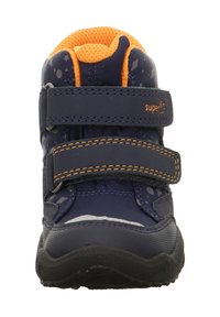 Dětské boty v námořnické modré barvě s oranžovými akcenty, dvěma suchými zipy, texturovaným svrškem, pevnou podešví a rozpraskaným vzorem po stranách.