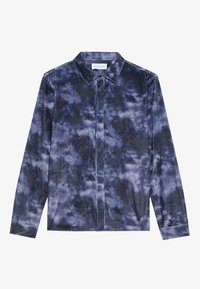 Camisa de botones en patrón de tie-dye en azul marino y gris, hecha de una textura de corduroy. Cuenta con un cuello clásico y mangas largas con puños de botón.