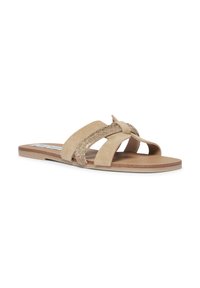 Sandales à glissière en daim beige avec des brides entrecroisées, ornées d'accents métalliques, semelle plate et texture lisse.