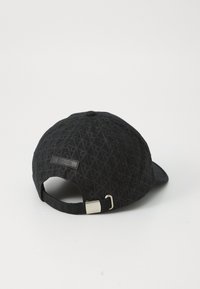 Casquette noire avec un motif texturé, présentant une étiquette de logo à l'arrière, une sangle ajustable et un design de visière arrondie.