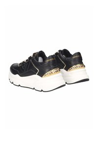 Sneaker in pelle nera con accenti dorati e suola bianca chunky, dotati di pannelli testurizzati e un design distintivo del tallone.