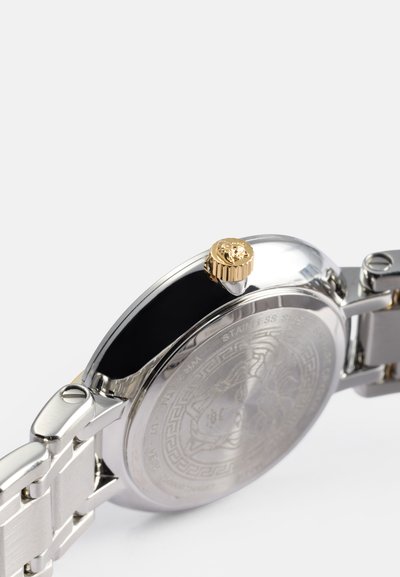 Orologio in acciaio inossidabile argento con superficie lucida, corona dorata e fondello inciso con un motivo di design dettagliato.