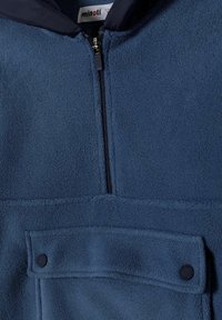 Giacca di pile blu con chiusura a zip, taschino sul petto con bottoni a scatto e una texture morbida. Presenta un colletto a contrasto.