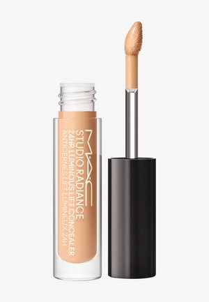 Correttore illuminante MAC Studio Radiance 24 ore con applicatore a bacchetta che mostra il prodotto cremoso beige sulla punta.