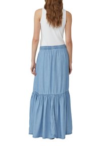 Gonna maxi in denim azzurro chiaro con design a strati, vita elastica e texture morbida, caratterizzata da una sezione inferiore svasata.