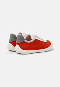 Röda kanvas sneakers med vita snören, grå detaljer vid hälen och en texturerad tyg. Lågprofil gummisula för komfort.