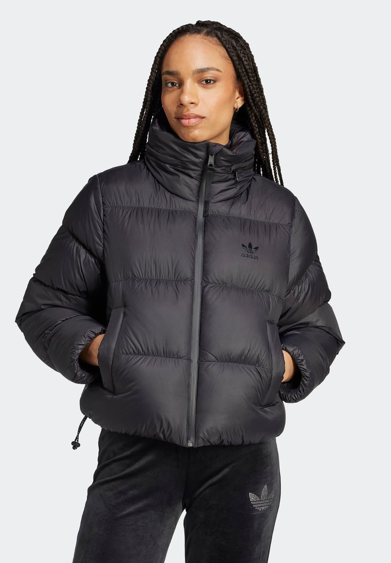 Giacca a vento nera con colletto alto, design trapuntato e chiusura con zip. Presenta il logo Adidas in nero sul petto e polsini elastici.