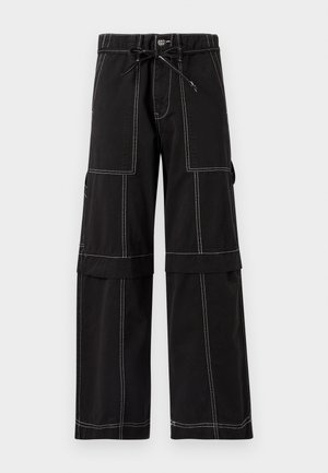 Juodos medvilninės krovininės kelnės su kontrastingomis baltomis siūlėmis, raišteliu liemens srityje, pločiais kojų apačioje ir didelėmis šoninėmis kišenėmis.