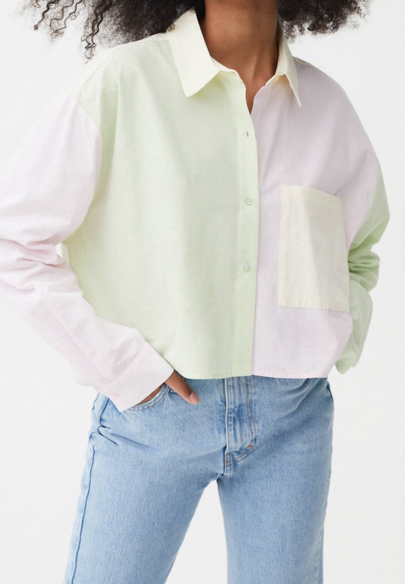 Camicia button-up tagliata in cotone verde chiaro e rosa. Caratterizzata da un colletto a punta e una tasca sul lato sinistro. Vestibilità casual.